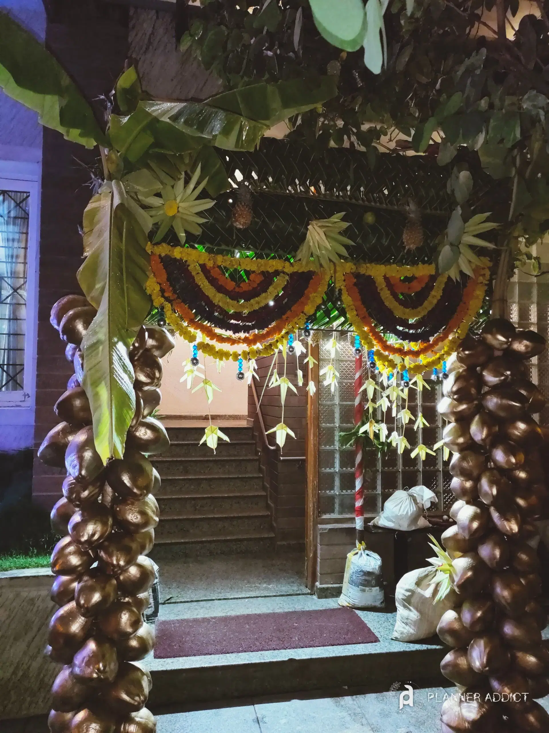 A chappara entrance at night by our crew: banana leaves, coconut-shell pillars and marigold drapes