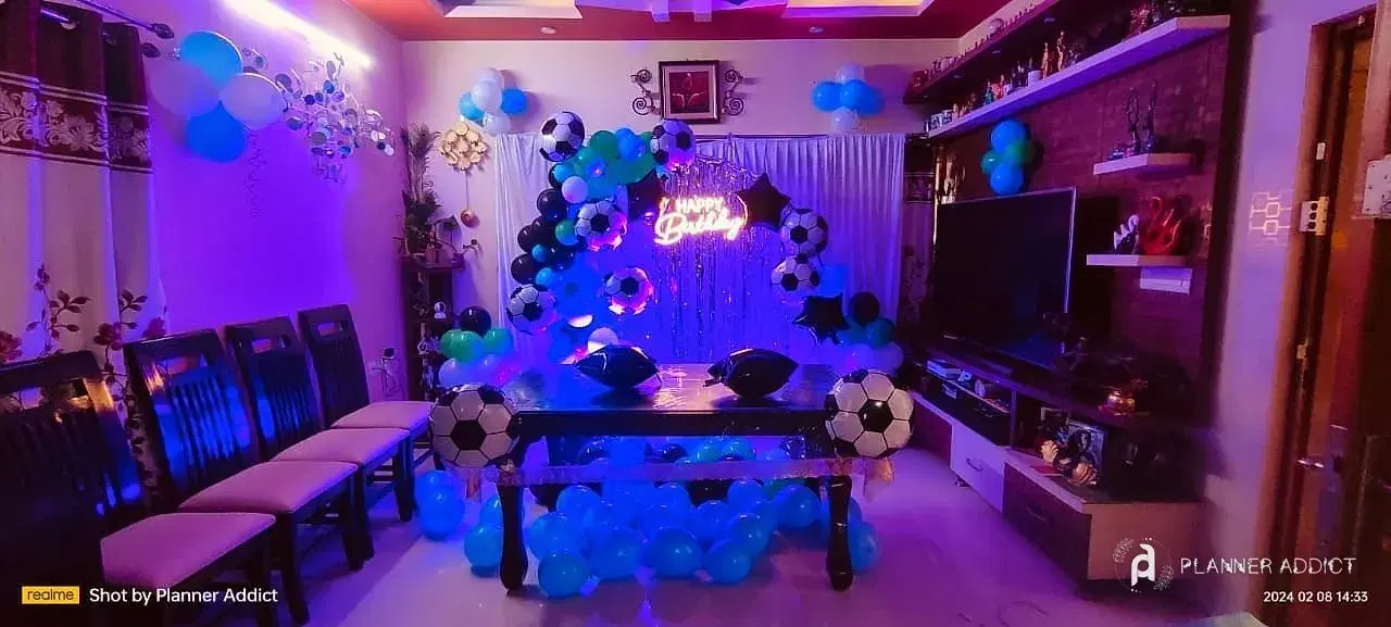Football-theme balloon set-up with a neon sign in a living room