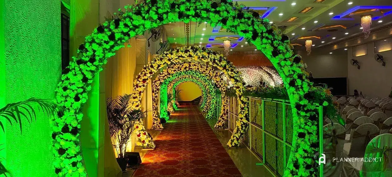 Tunnel of flower arches lit green over a patterned carpet