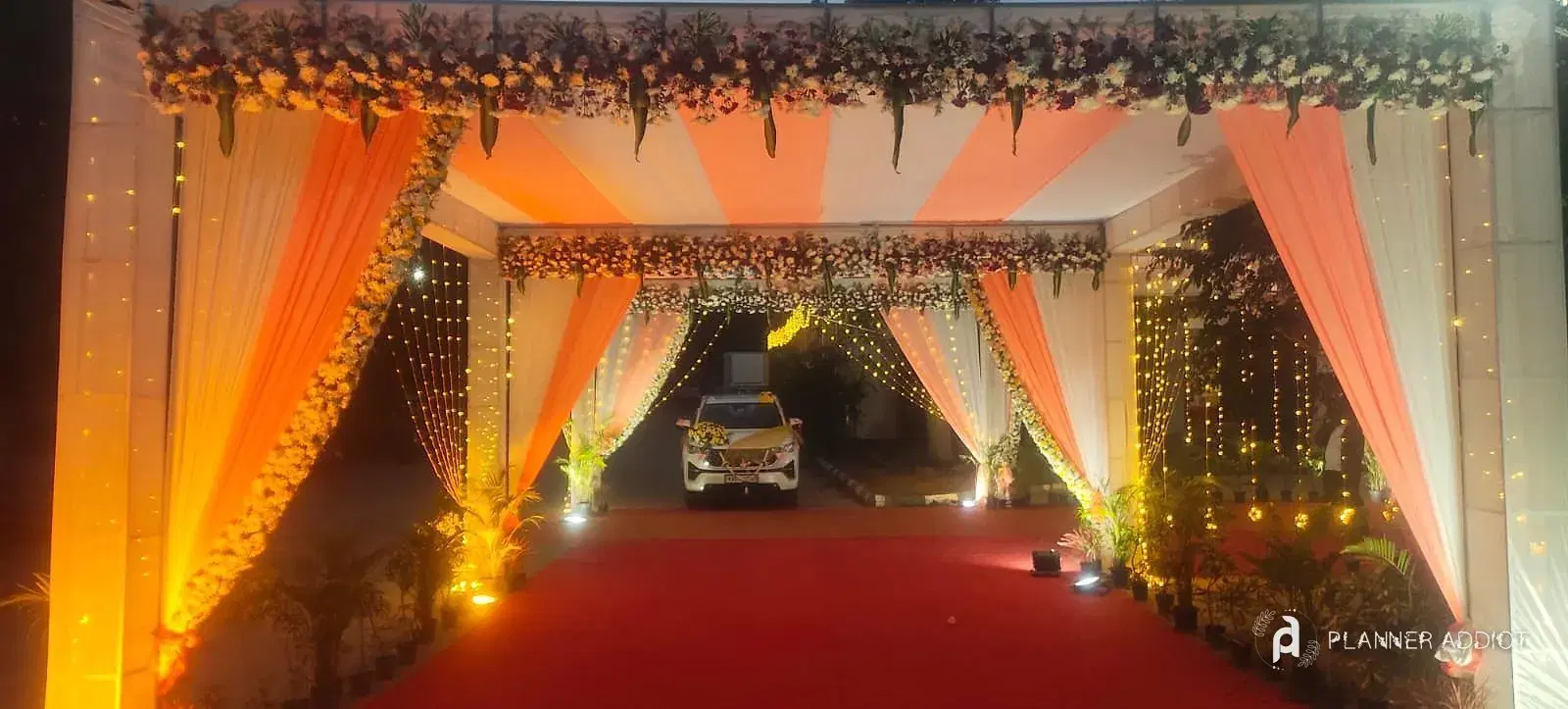 Walkway of peach and white drapes under a flower canopy