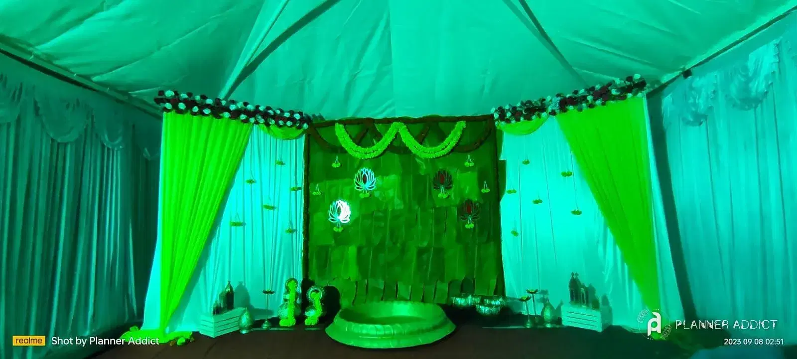 Tent with green drapes and a leaf backdrop