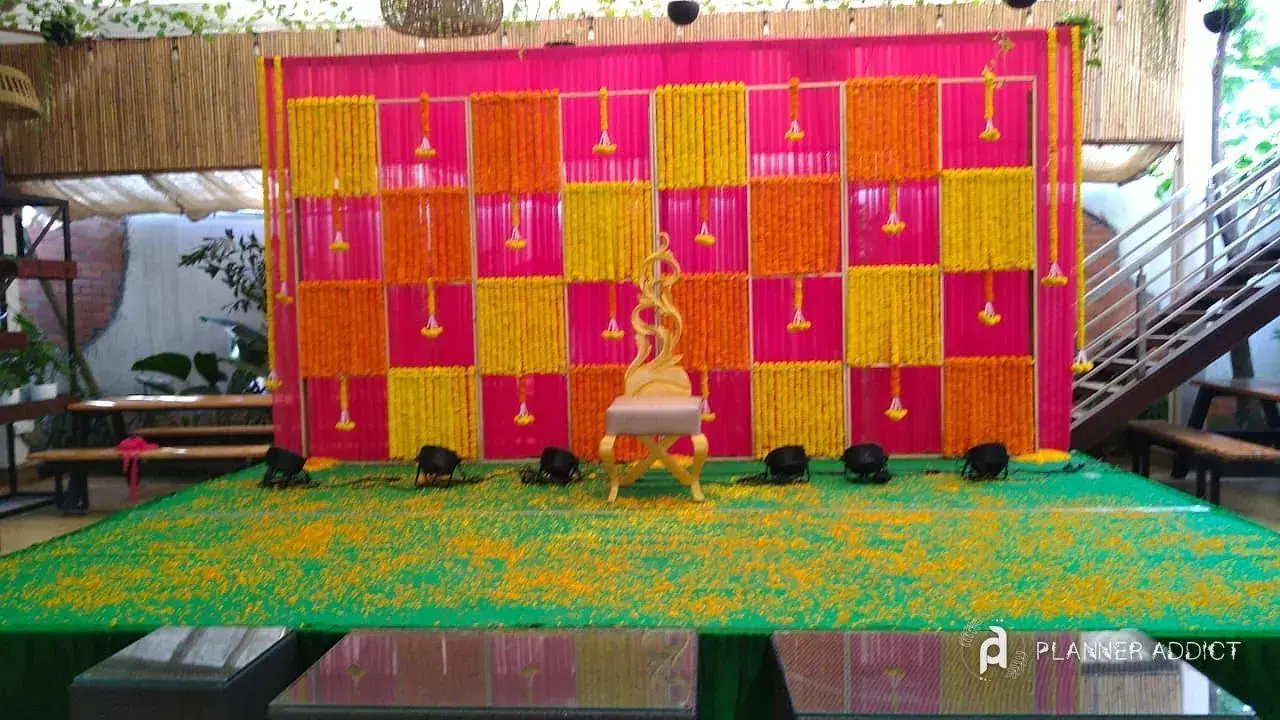 Pink, orange and yellow marigold wall with a gold chair