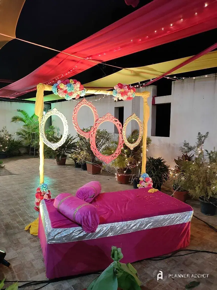 Pink seating with flower ring frames under a coloured canopy