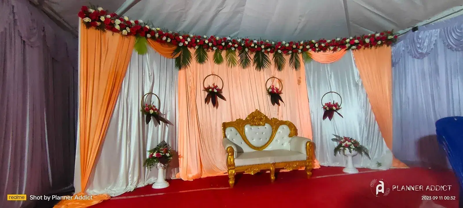 Tent stage with peach and white drapes and a gold sofa