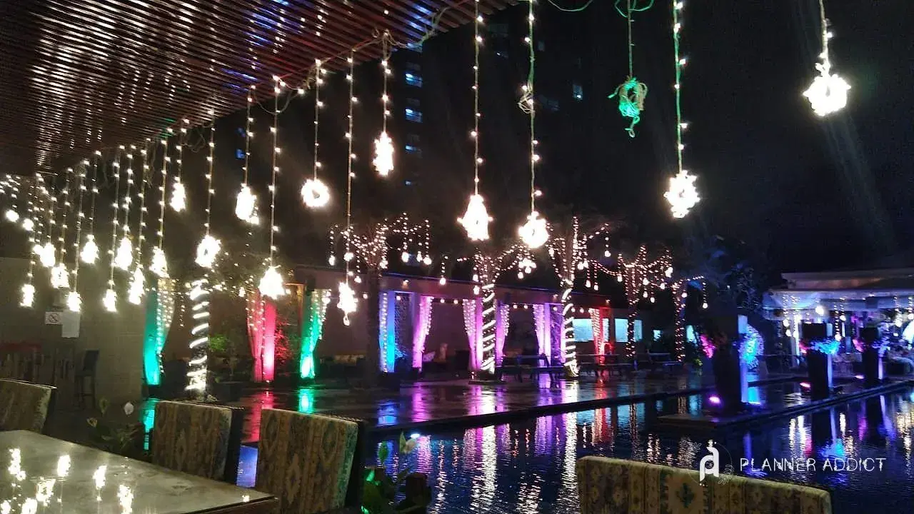 Poolside dinner under hanging lanterns and curtain lights