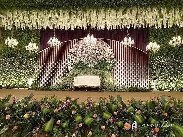 Stage with a flower moon gate, chandeliers, a leaf wall and a white sofa