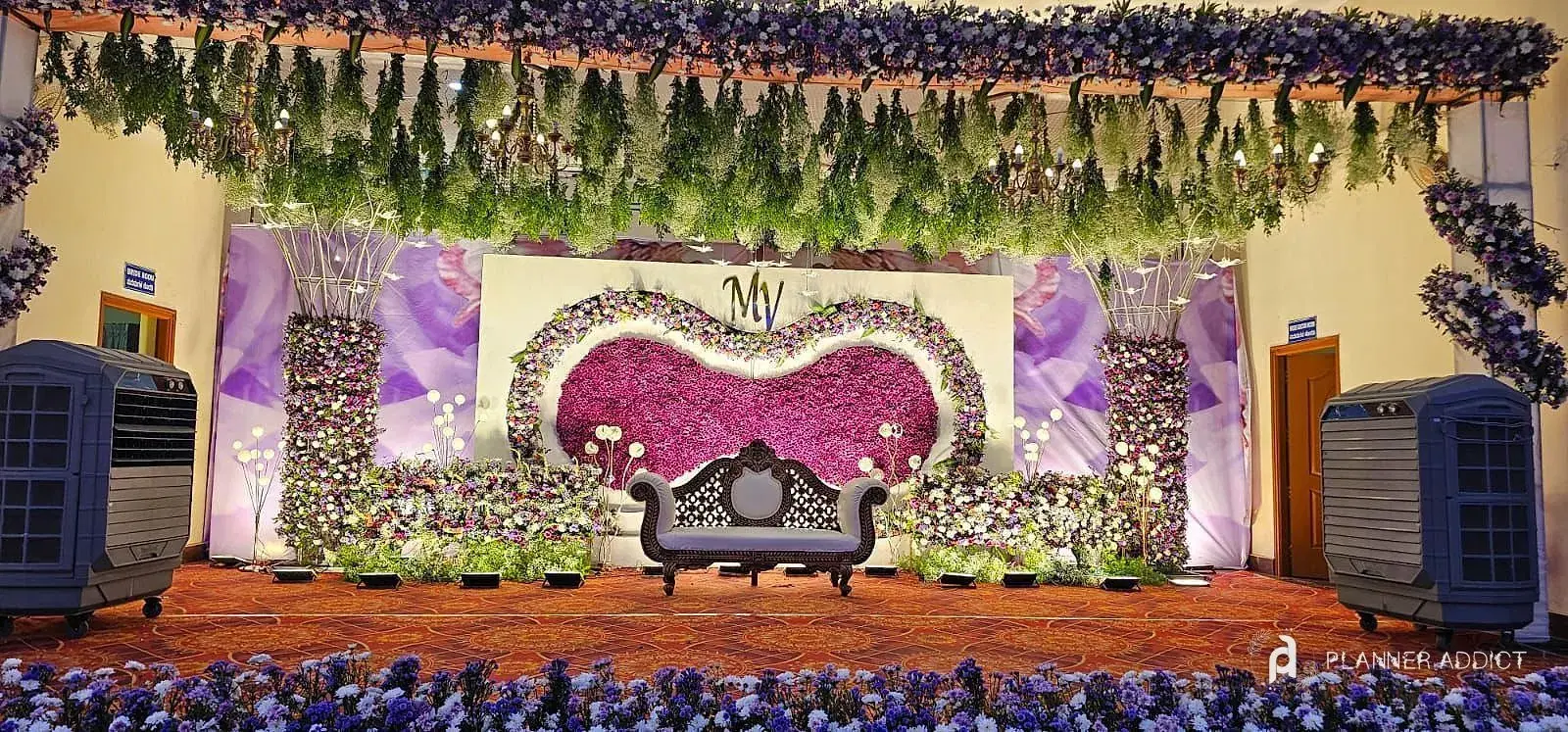 Stage with a heart-shaped flower frame, lilac panels and a carved sofa