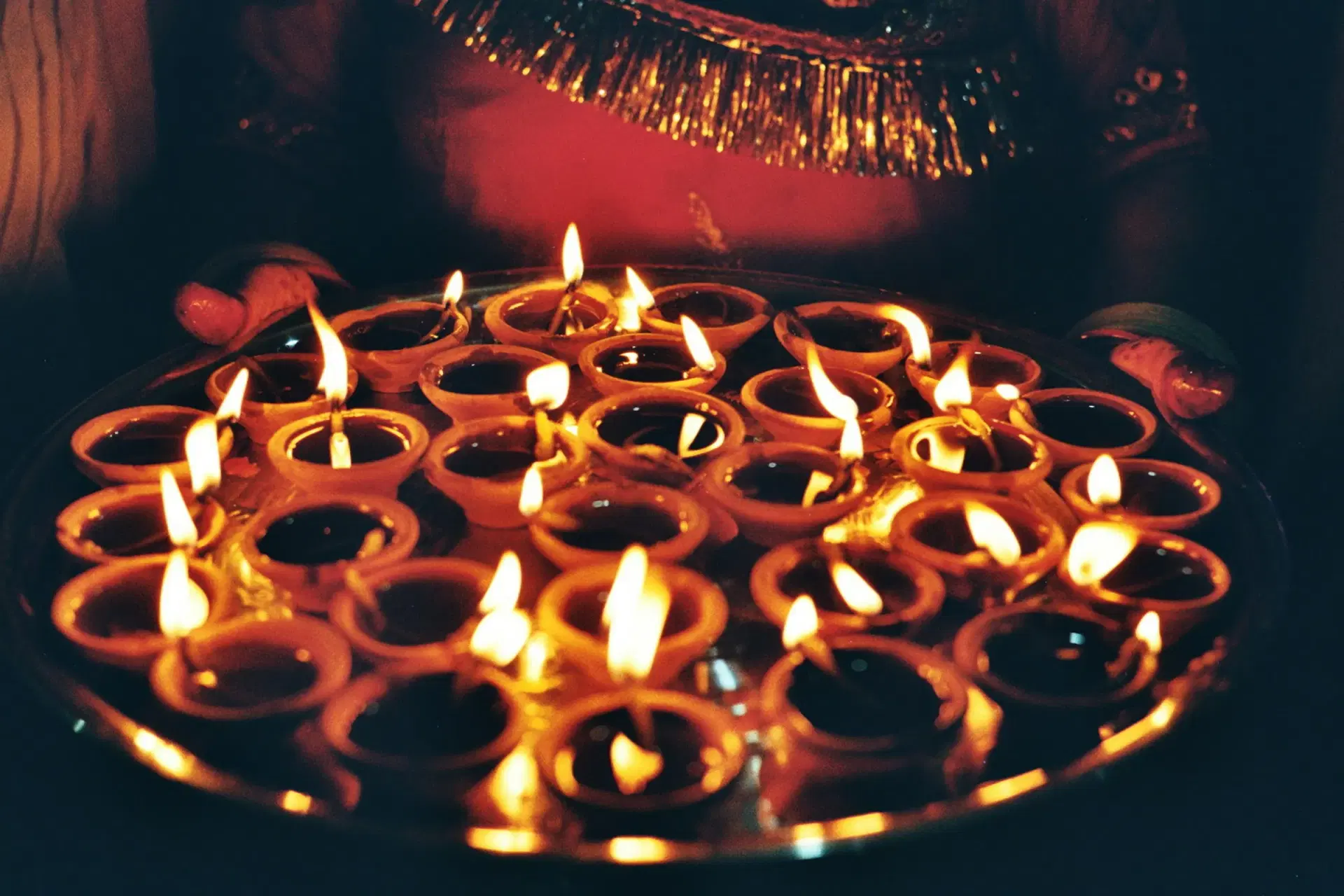 A platter of lit clay diyas