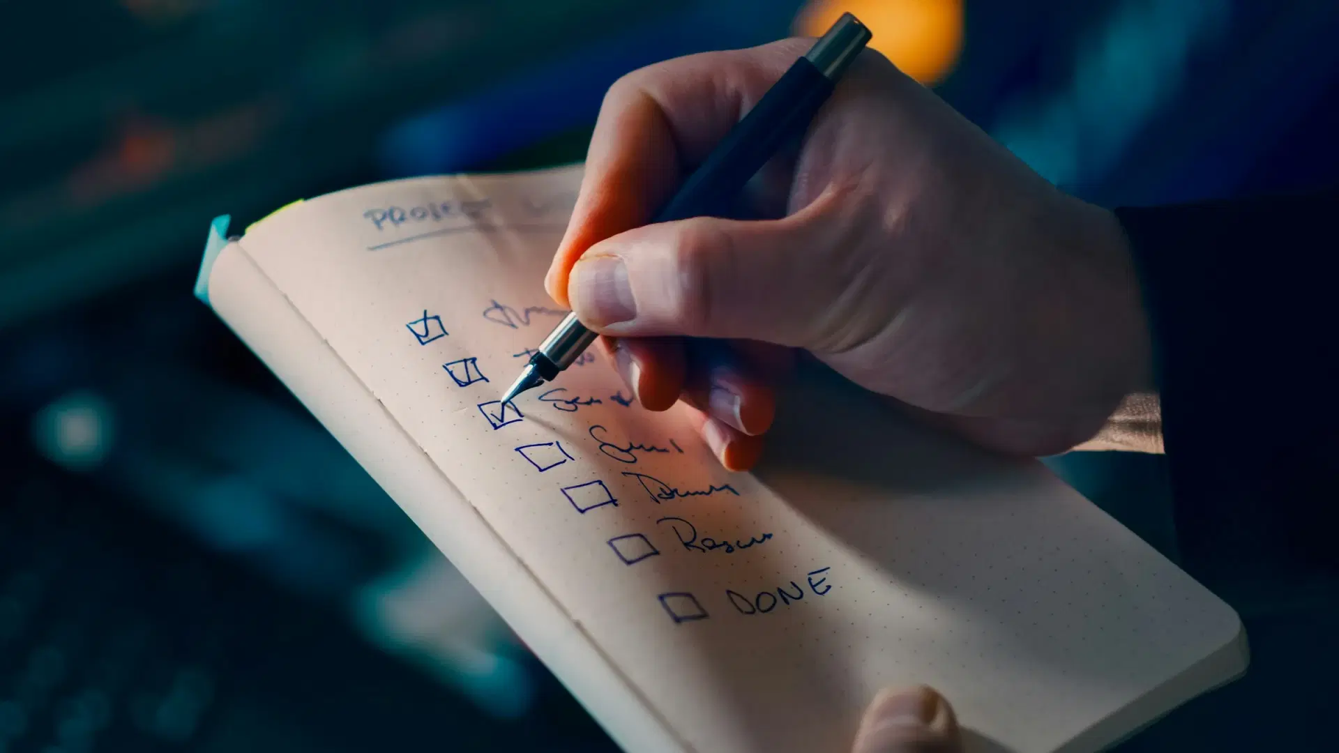 Hand ticking items off a checklist in a notebook