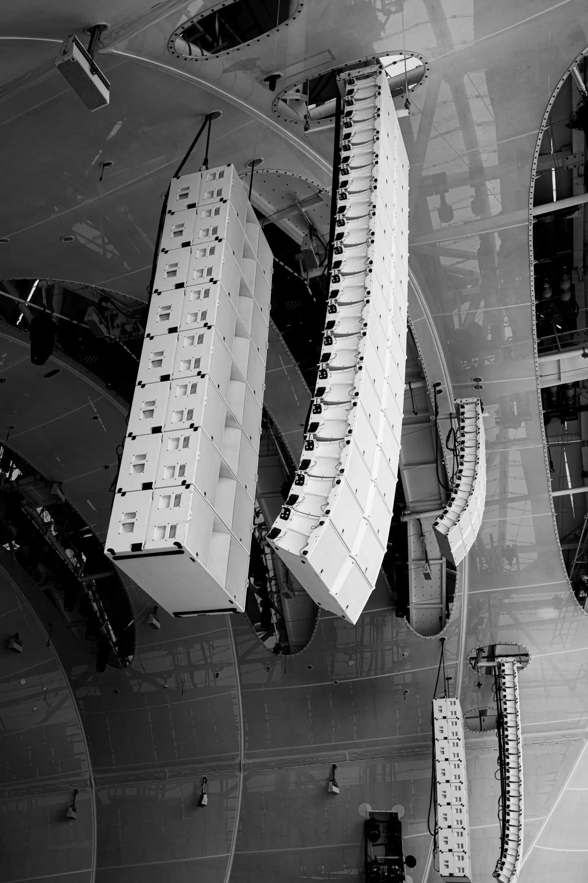 Line-array speakers hanging from a truss above a stage