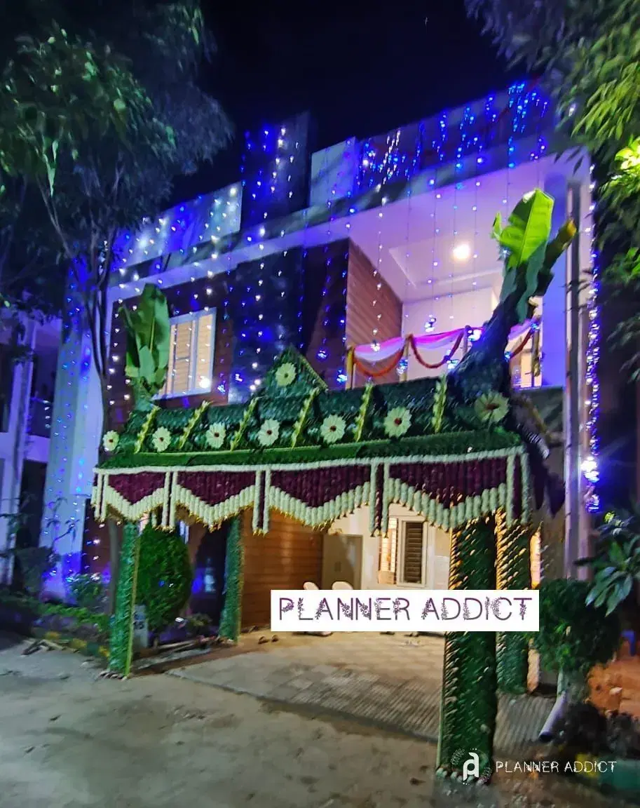 House front with a leaf pandal and serial lights at night