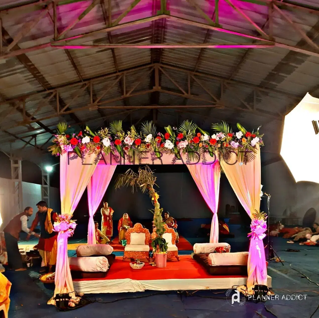 Mantapa with pink drapes and flower garlands in a covered hall