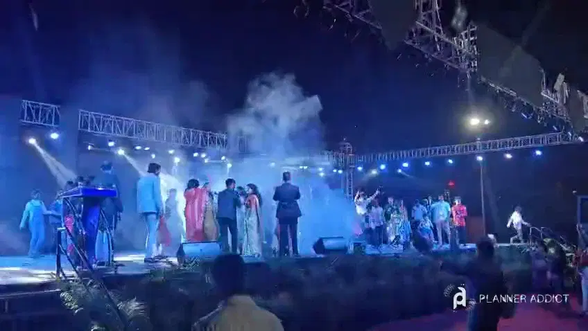 Night stage with coloured beams, smoke and performers