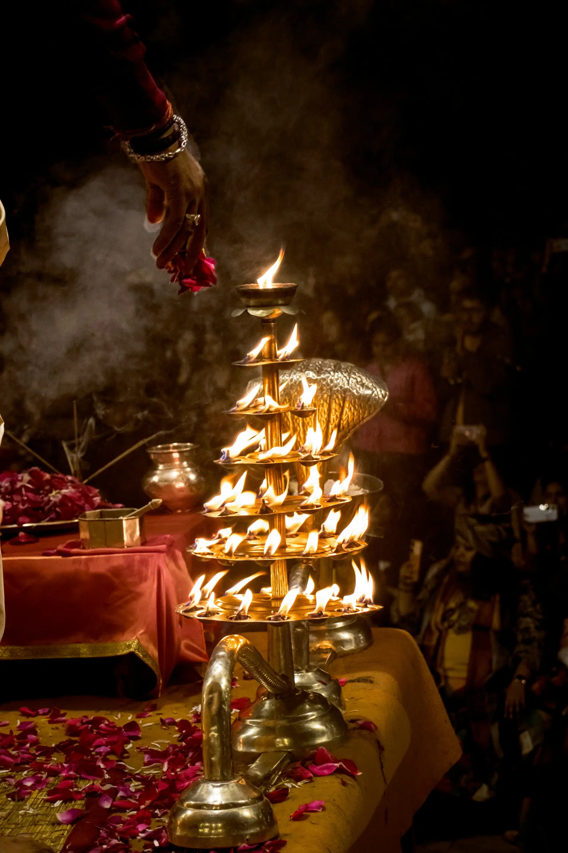 A tiered brass aarti lamp with many flames