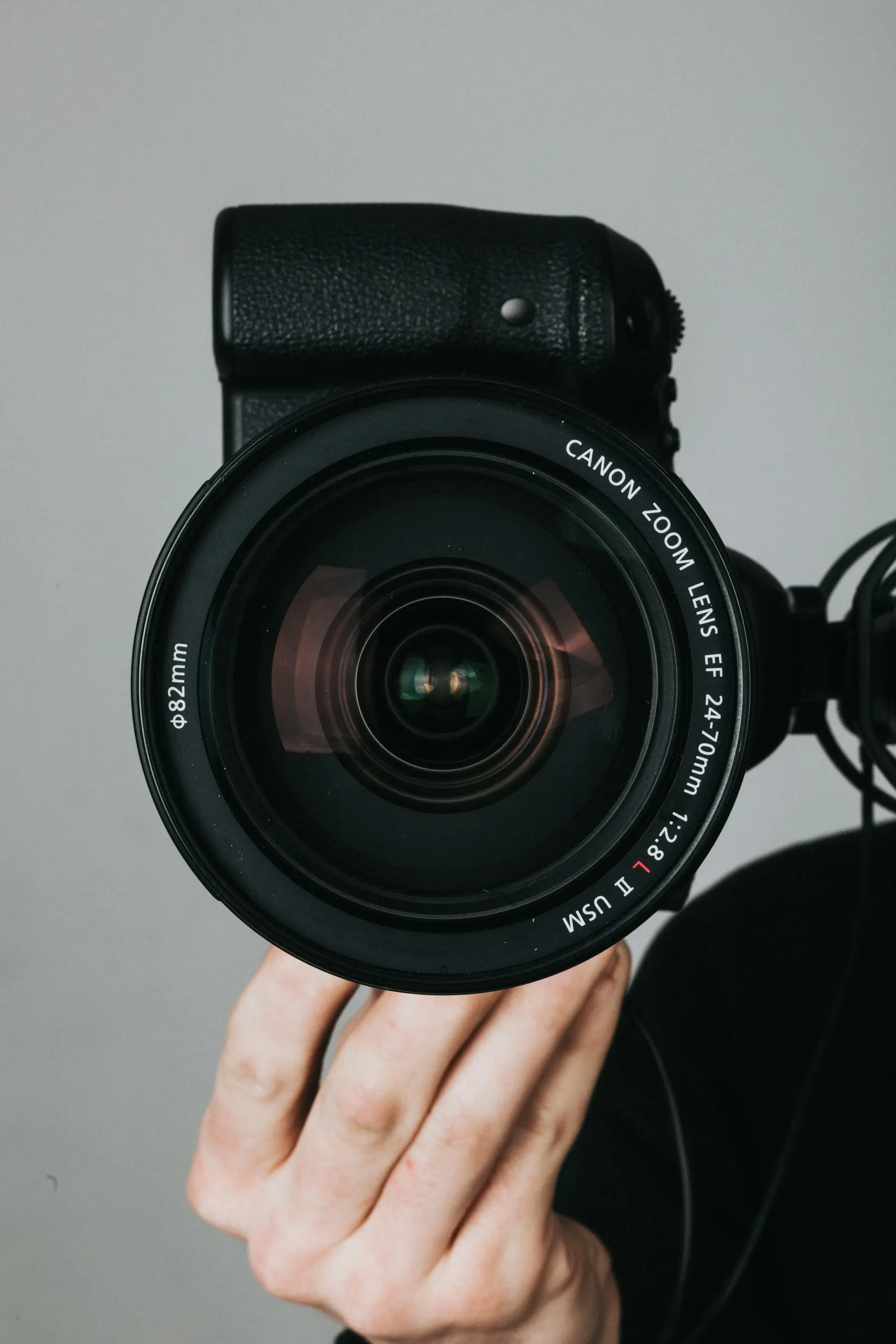 Photographer holding a camera with a large zoom lens
