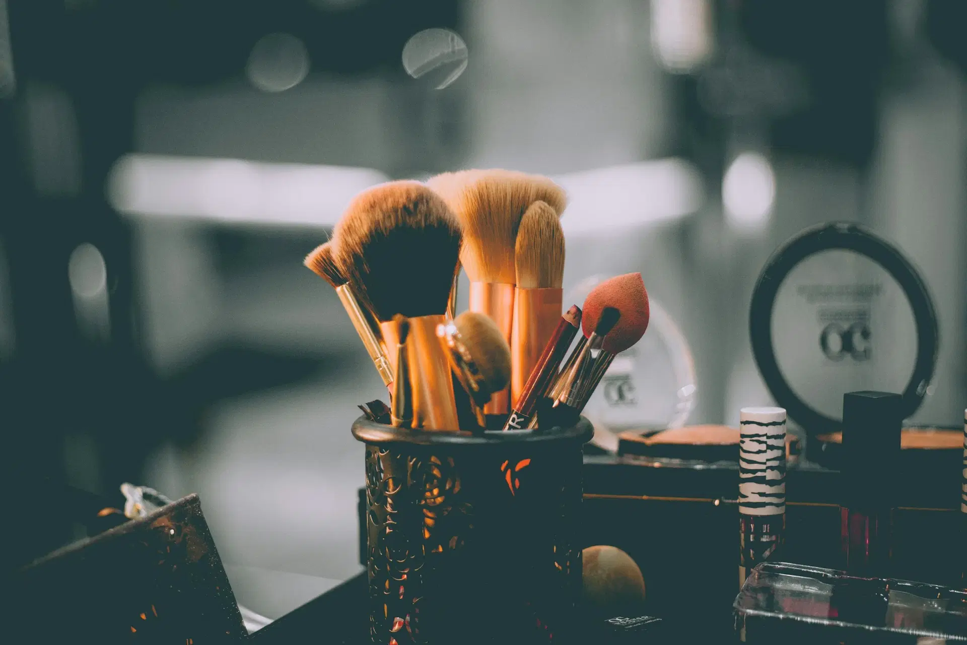 Makeup brushes in a holder on an artist's table
